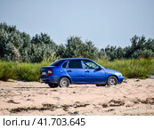 A blue car lada kalina under the sun on a sandy road. (2016 год). Редакционное фото, фотограф Леонид Еремейчук / Фотобанк Лори