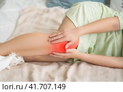 Knee pain, woman suffering from ache and doing self-massage at home. Стоковое фото, фотограф Станислав Тарко / Фотобанк Лори