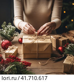 An unrecognizable woman wraps Christmas gifts in craft paper. Стоковое AI-изображение, AI-художник Margarita Davchenko / Фотобанк Лори