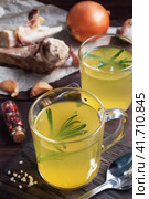 Homemade beef bone and vegetable broth with turmeric seasoning in a glass. Healthy food with collagen and amino acids. Copy space. Стоковое фото, фотограф Глущенко Елена / Фотобанк Лори
