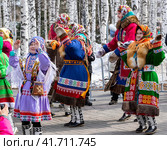 Девочка и женщины в национальной одежде народов Севера ханты танцуют на фольклорном празднике "Вороний день", г. Ханты-Мансийск, 2018 год. Редакционное фото, фотограф Любовь Демус / Фотобанк Лори
