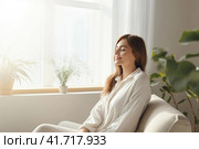 A seated young woman relaxes on the sofa. Стоковое AI-изображение, AI-художник Татьяна  Бральнина / Фотобанк Лори
