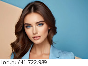Close-up portrait of beautiful sensual caucasian woman with brown hair wearing blue clothes on a blue background.. AI. Стоковое AI-изображение, AI-художник Sergey Grishin / Фотобанк Лори