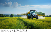 Watering, treating fields with crops with Pesticides and Herbicides on a tractor. Agricultural industry. Стоковое AI-изображение, AI-художник Ирина Ручушкина / Фотобанк Лори