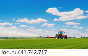 Watering, treating fields with crops with Pesticides and Herbicides on a tractor. Agricultural industry. Стоковое AI-изображение, AI-художник Ирина Ручушкина / Фотобанк Лори