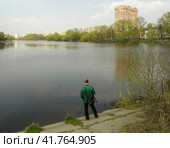 Рыбак с удочкой поймал рыбу, река Пехорка, Балашиха. Fisherman is getting a small fish from the water. (2019 год). Редакционное фото, фотограф Александр Кузнецов / Фотобанк Лори