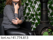 Sore throat and cough, woman with pain in neck in a room with stove heating. Стоковое фото, фотограф Станислав Тарко / Фотобанк Лори