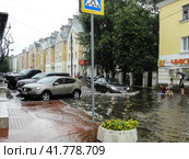 Наводнение в центре Твери. Traffic through the flooded street with teenagers enjoying there. (2016 год). Редакционное фото, фотограф Александр Кузнецов / Фотобанк Лори