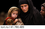 Portrait of Refugees on middle east looking at camera. Homeless people, unhappy and frightened, shawl camps,  Generative AI. Стоковое AI-изображение, AI-художник Анна Кривицкая / Фотобанк Лори
