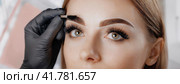 Young woman face during professional eyebrow mapping procedure before permanent makeup and lamination. Artist does long-lasting styling of the eyebrows with hair coloring. Panorama with copy space. Стоковое AI-изображение, AI-художник Igor Tichonow / Фотобанк Лори
