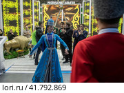 Люди в национальных костюмах танцуют у стенда Республики Адыгея на Международной выставке-форуме "Россия" на территории выставочного комплекса ВДНХ в городе Москве, Россия (2023 год). Редакционное фото, фотограф Николай Винокуров / Фотобанк Лори