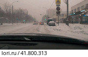 A first-person view from the windshield of a car while driving around the city in heavy snowfall. Russian. Moscow. 02.12.23 (2023 год). Редакционное видео, видеограф Ярославский Максим / Фотобанк Лори