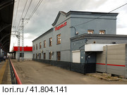 Серое здание вокзала в городе Подольск, Московская область. Grey building of Podolsk railway station with the name of the city and cloudy sky on background. Daylight view. (2021 год). Редакционное фото, фотограф Александр Кузнецов / Фотобанк Лори