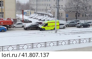 Автомобиль скорой медицинской помощи с включенными проблесковыми сигналами едет зимой в городе через дорожную пробку (2023 год). Редакционное видео, видеограф Цибаев Алексей / Фотобанк Лори