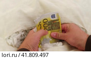 The money in euros is hidden in a stash in the pillow. A torn pillow with euro banknotes. Стоковое видео, видеограф Андрей Журавлев / Фотобанк Лори