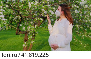 Pregnant woman in medical face mask n95 with apple tree flowers in spring nature. Happiness of pregnancy during covid epidemic, coronavirus pandemic quarantine. Стоковое видео, видеограф Андрей Журавлев / Фотобанк Лори