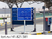 Stand at entrance to Muscat Airport informing motorists about free 10 minutes of parking for disembarking and picking up passengers (2023 год). Редакционное фото, фотограф Евгений Ткачёв / Фотобанк Лори