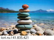 Pile of smooth stones stacked on a pebbly beach, symbolizing balance and stability, with the ocean backdrop. Стоковое AI-изображение, AI-художник Ирина Михайличенко / Фотобанк Лори