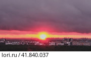 Hot red sun behind the silhouettes of city buildings, timelapse. Summer sunset in the sky haze with night houses, time-lapse. Стоковое видео, видеограф Андрей Журавлев / Фотобанк Лори