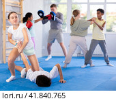 Tween girl applying armlock to face-down boy in mock fight at self-defense classes. Стоковое фото, фотограф Яков Филимонов / Фотобанк Лори