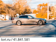 Side view of BMW 5 series in motion. Beige sedan car moving on the street. Редакционное фото, фотограф Константин Григорьев / Фотобанк Лори