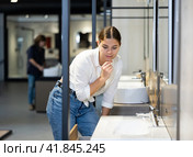 Woman looking to buy new bathroom sink in harware store. Стоковое фото, фотограф Яков Филимонов / Фотобанк Лори