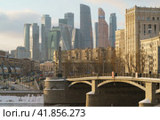 Moscow,  Russia - February 5, 2021: Moscow cityscape in winter sunny day. Stalinist architecture, buildings of Moscow International business Center and Borodinsky Bridge. Редакционное фото, фотограф YuryKara / Фотобанк Лори