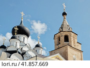 Старица, Тверская область, Россия, лето 2021 года. Купола над Собором Успения Пресвятой Богородицы и колокольня над часовней Иова в Старицком Свято-Успенском мужском монастыре. Голубое небо, белые движущиеся облака. Редакционное фото, фотограф Сергей Никифоров-Гордеев / Фотобанк Лори