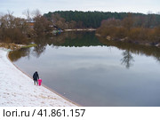 Мама с ребенком гуляет по берегу реки зимним днем. Стоковое фото, фотограф YuryKara / Фотобанк Лори