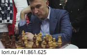 Сергей Карякин, гроссмейстер, чемпион мира по шахматам играет в шахматы с маленьким мальчиком у стенда Республики Калмыкия на выставке-форуме "Россия" на ВДНХ в городе Москве, Россия (2023 год). Редакционное видео, видеограф Николай Винокуров / Фотобанк Лори