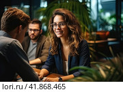 A young beautiful girl with long hair is sitting in a spacious office at a laptop and smiling. Generated by AI. Стоковое AI-изображение, AI-художник Ярославский Максим / Фотобанк Лори