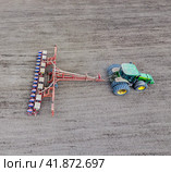 Sowing of corn. Tractor with a seeder on the field. Using a seeder for planting corn. Стоковое фото, фотограф Леонид Еремейчук / Фотобанк Лори