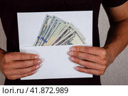 Money in white envelope in the hands of a man. Dollars, a wad of dollars. Стоковое фото, фотограф Леонид Еремейчук / Фотобанк Лори