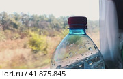 A bottle of sparkling water on the background of a train window while driving. The concept of long-distance travel. Стоковое видео, видеограф Ярославский Максим / Фотобанк Лори