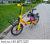 Электровелосипед и электросамокат сервиса WHOOSH у края тротуара (2023 год). Редакционное фото, фотограф Вячеслав Палес / Фотобанк Лори