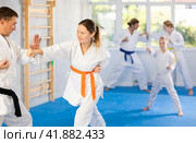 Woman is paired with man teacher to learn how to strike and rehearses blocking opponent. Стоковое фото, фотограф Яков Филимонов / Фотобанк Лори