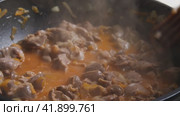 Замедленная съемка деревянной лопаткой, перемешивающей куриную жижу с овощами, приготовленными в воке. От блюда поднимается пар. Крупный план. Приготовление пищи в азиатском стиле. Стоковое видео, видеограф Воловодов Владимир / Фотобанк Лори