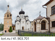 Старица, Тверская область, Россия, август 2021 года. Кирпичная часовня Иова и Успенский собор с куполами и крестами в Старицком Свято-Успенском мужском монастыре. Редакционное фото, фотограф Сергей Никифоров-Гордеев / Фотобанк Лори