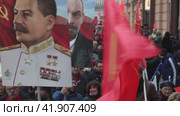 Участники шествия КПРФ несут большие портреты лидеров СССР Иосифа Сталина и Владимира Ленина, посвященного 100-й годовщине Октябрьской социалистической революции, по Тверской улице в центре города Москвы, Россия (2017 год). Редакционное видео, видеограф Николай Винокуров / Фотобанк Лори