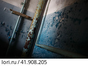 The interior of an abandoned house. Peeling paint on walls and pipes. Gloomy mood. A dark room with blue walls. Oblique angle. Стоковое фото, фотограф Андрей Степанов / Фотобанк Лори