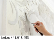 Female worker puts putty mortar on a wall with a bas-relief. Стоковое фото, фотограф Aleksandra Selivanova / Фотобанк Лори