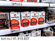 Takayama motor oil in metal canisters on the shelf at a superstore (2023 год). Редакционное фото, фотограф FotograFF / Фотобанк Лори