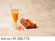 Pumpkin desserts on a pale pink background. Pumpkin smoothie in a glass with drinking straw and pumpkin mousse on a wooden serving board.  Focus stacking. Copy space. Стоковое фото, фотограф Роман Дзюбало / Фотобанк Лори