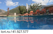 Video of a Greek landscape with a palm tree in the foreground. and tourist hotel under a mountain on background. Crete, Greece. Стоковое видео, видеограф Сергей Пристяжнюк (Serg Zastavkin) / Фотобанк Лори