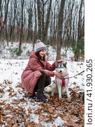 Russian young girl clung to Siberian husky lovingly against winter background in forest. Стоковое фото, фотограф Татьяна Терехина / Фотобанк Лори