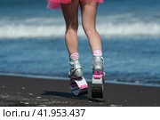 Athletic woman legs in sports boots Kangoo Jumps and short skirt running on beach during aerobic exercise outdoors. Rear view low section, crop shot (2022 год). Редакционное фото, фотограф А. А. Пирагис / Фотобанк Лори