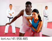 Woman and african american man practice painful grips in self-defense lessons. Стоковое фото, фотограф Яков Филимонов / Фотобанк Лори