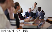 Two respectable mid-aged male executive managers watching presentation of reports at staff meeting sitting at conference table together with corporate business team office. Стоковое видео, видеограф Яков Филимонов / Фотобанк Лори