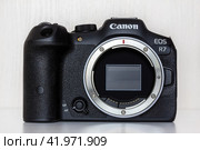 Krasnodar, Russia - December 28, 2023: mirrorless camera Canon eos R7 with RF mount without lens front view. Редакционное фото, фотограф Андрей С / Фотобанк Лори