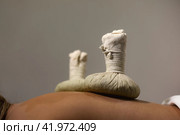 Health Thai method herbal massaging, herb compresses bag standing on woman back, spa room at shadow. Relaxing massage for lady back at massage salon. Relax spa massaging concept. Copy ad text space. Стоковое фото, фотограф Aleksandr Golubev / Фотобанк Лори
